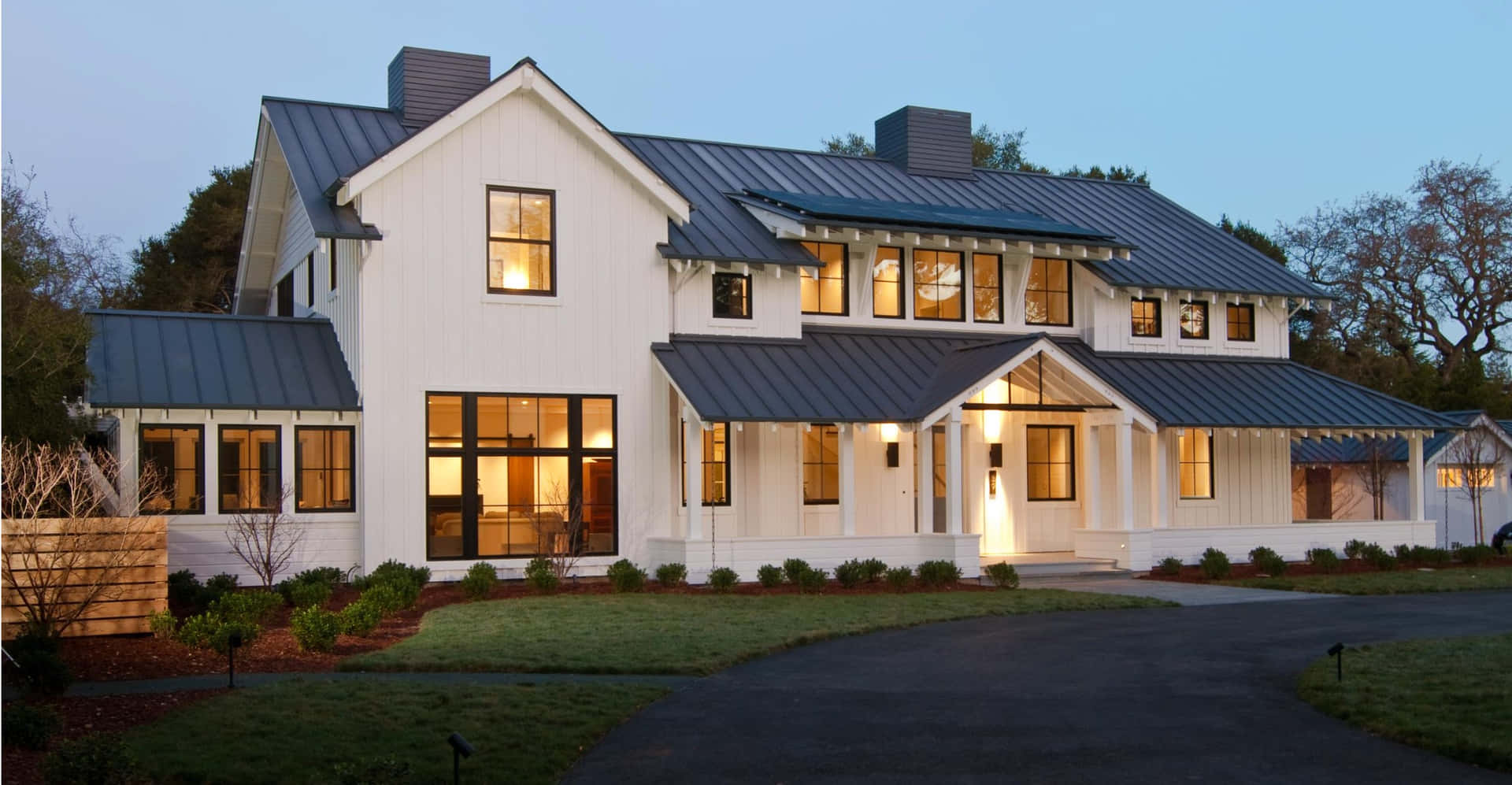A White House With A Metal Roof And A Driveway