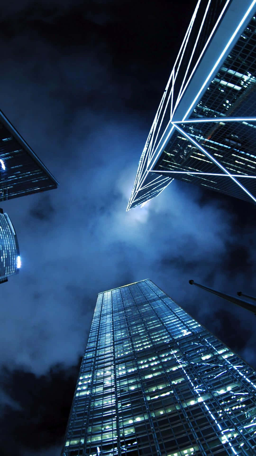 Edificiosmodernos De Iphone Con Destellos Azules En Una Ciudad Nocturna. Fondo de pantalla