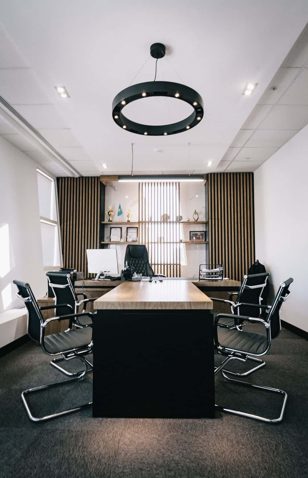 A Modern Office With A Black Table And Chairs