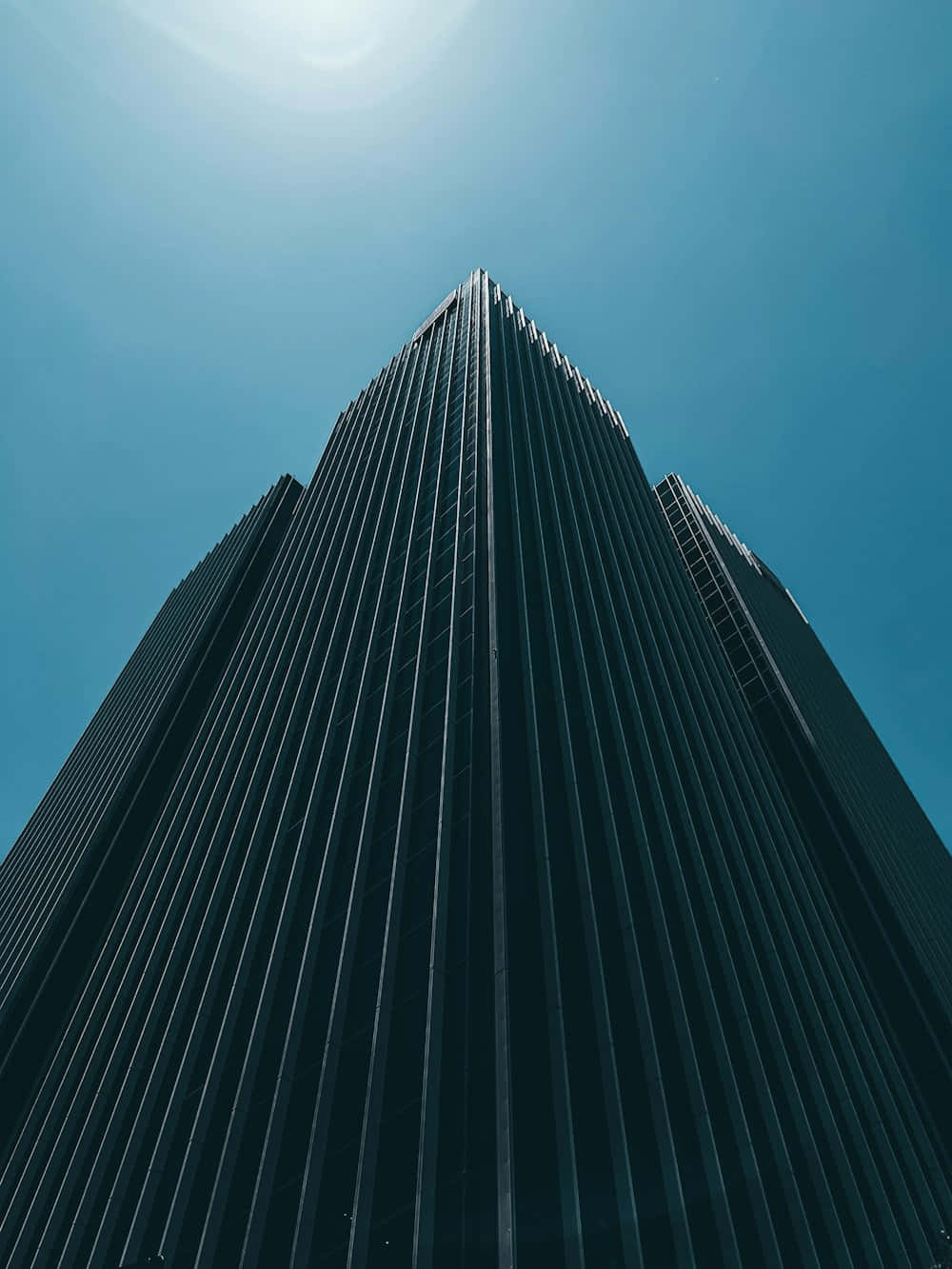 Modern_ Skyscraper_ Against_ Blue_ Sky Wallpaper