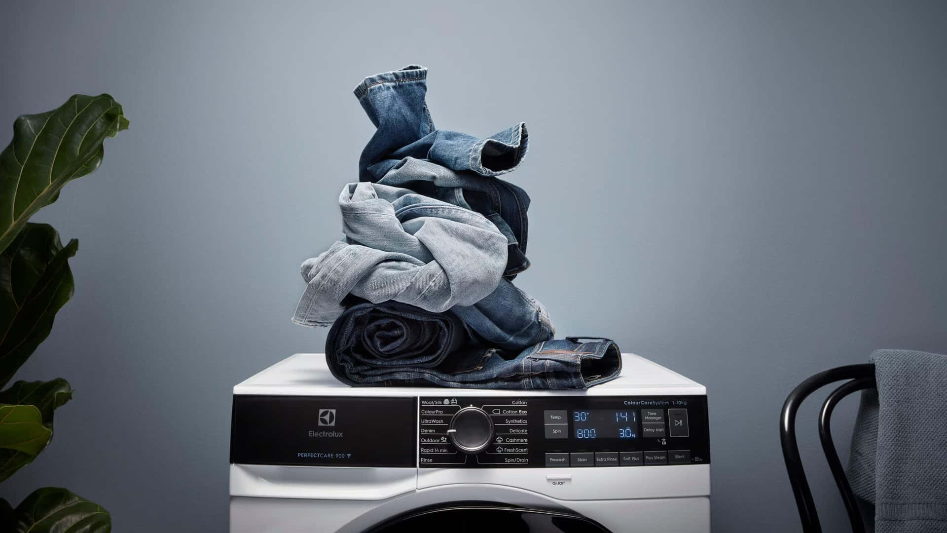 Modern Washing Machine With Stacked Jeans Wallpaper
