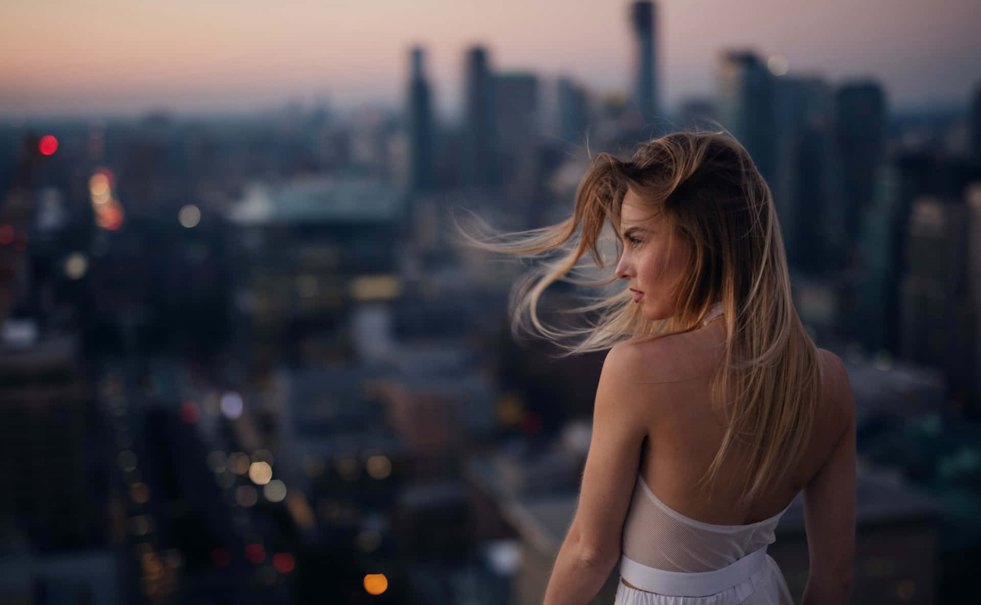 A Woman Is Standing On A Rooftop Overlooking A City Wallpaper