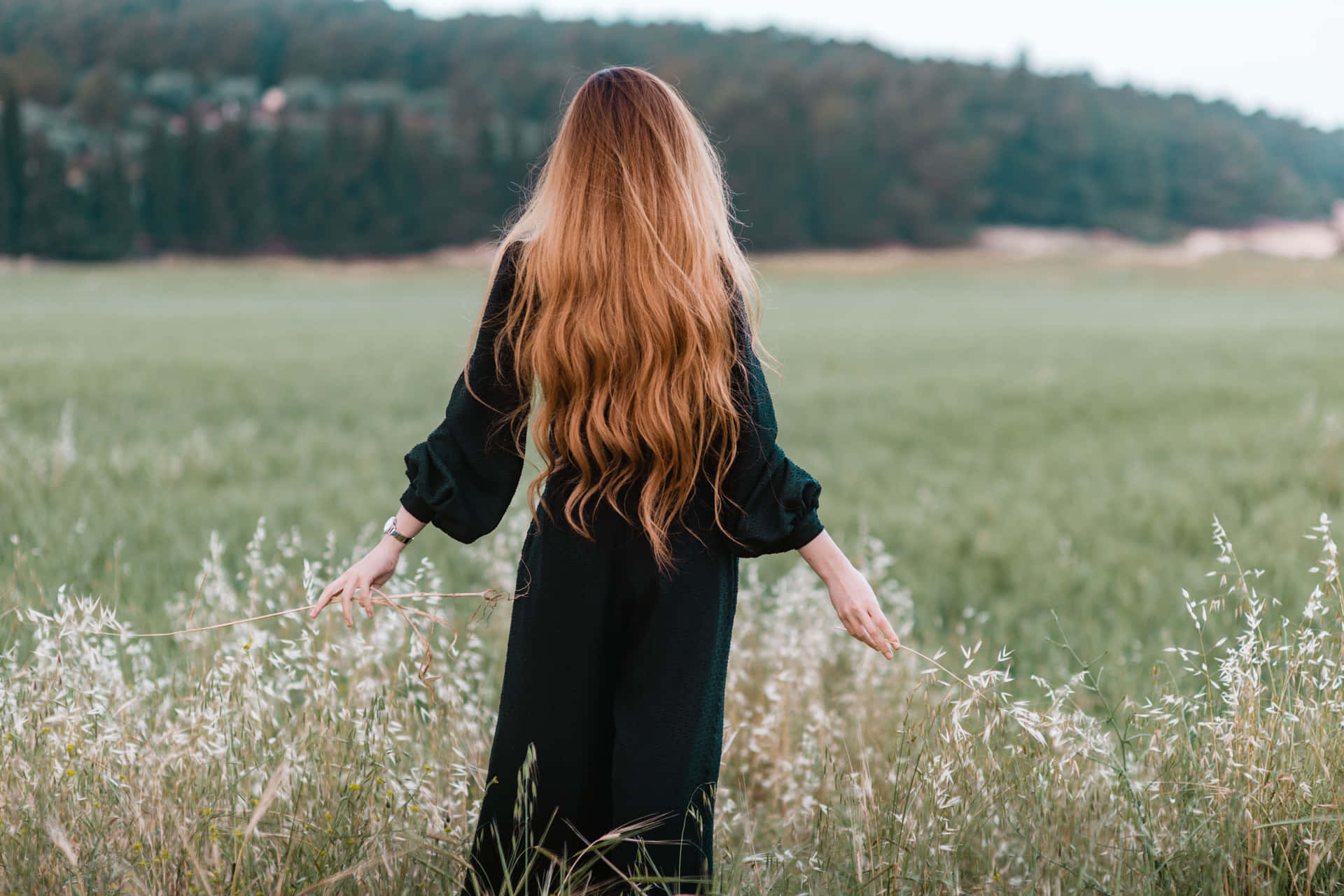 A Woman With Long Hair Standing In A Field Wallpaper