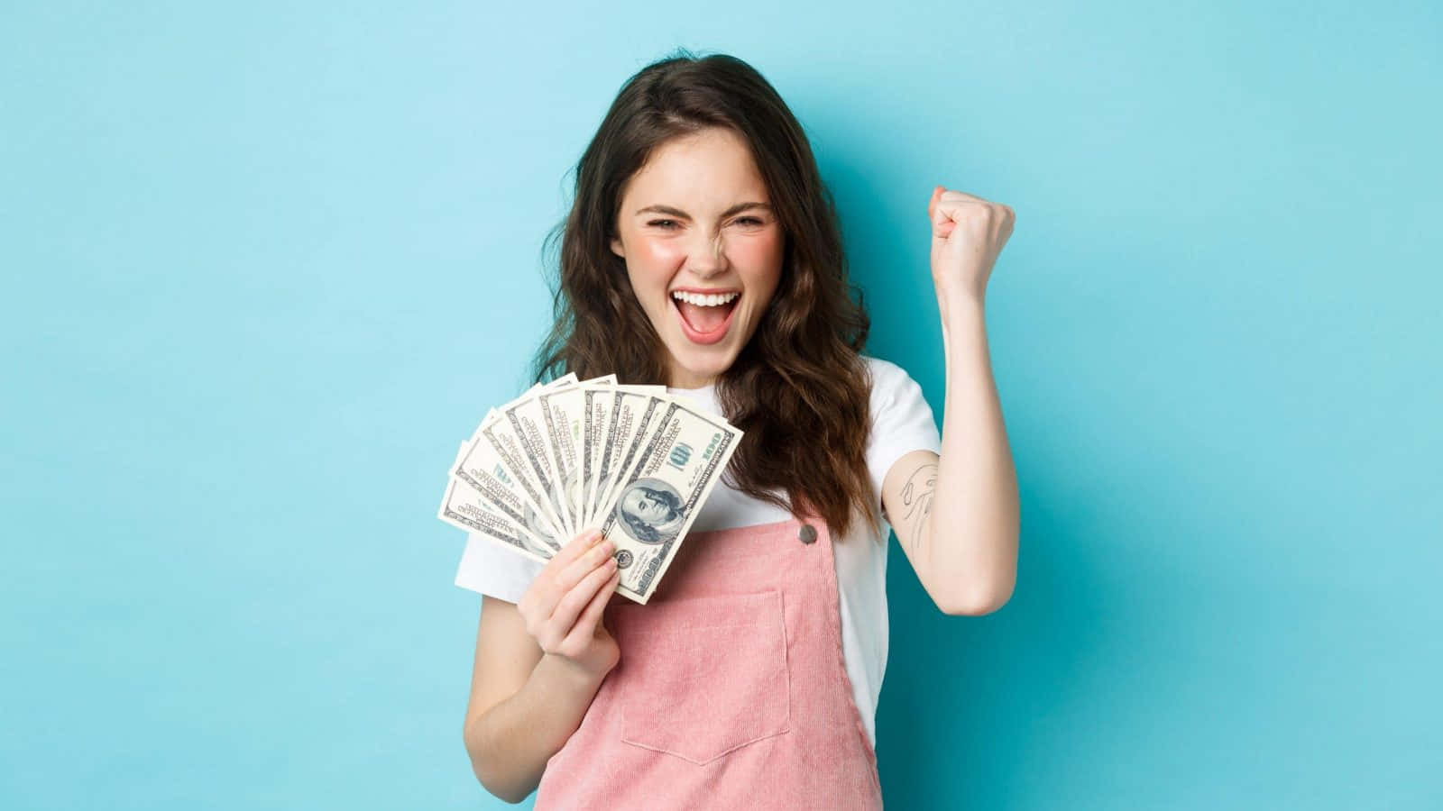 A Woman Holding Up Money And Smiling