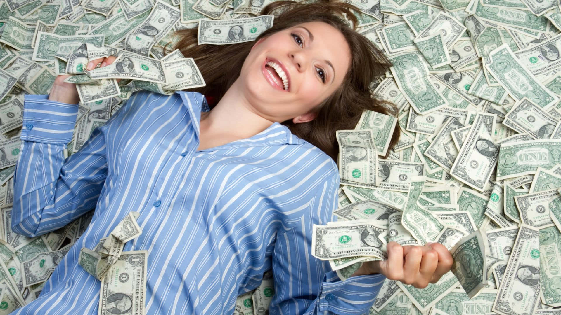 A Woman Laying On A Pile Of Money