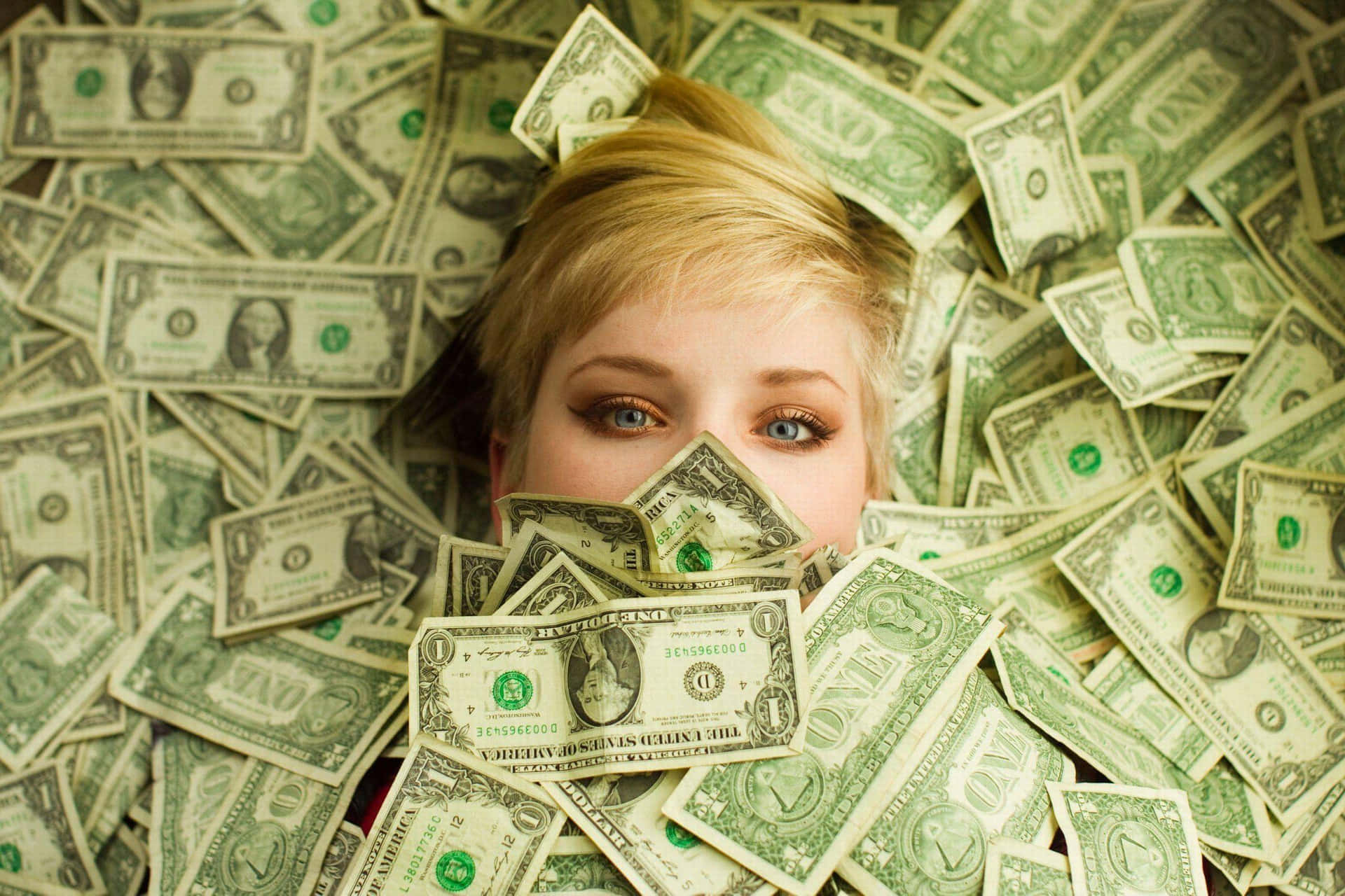 A Woman Is Hiding Behind A Pile Of Money