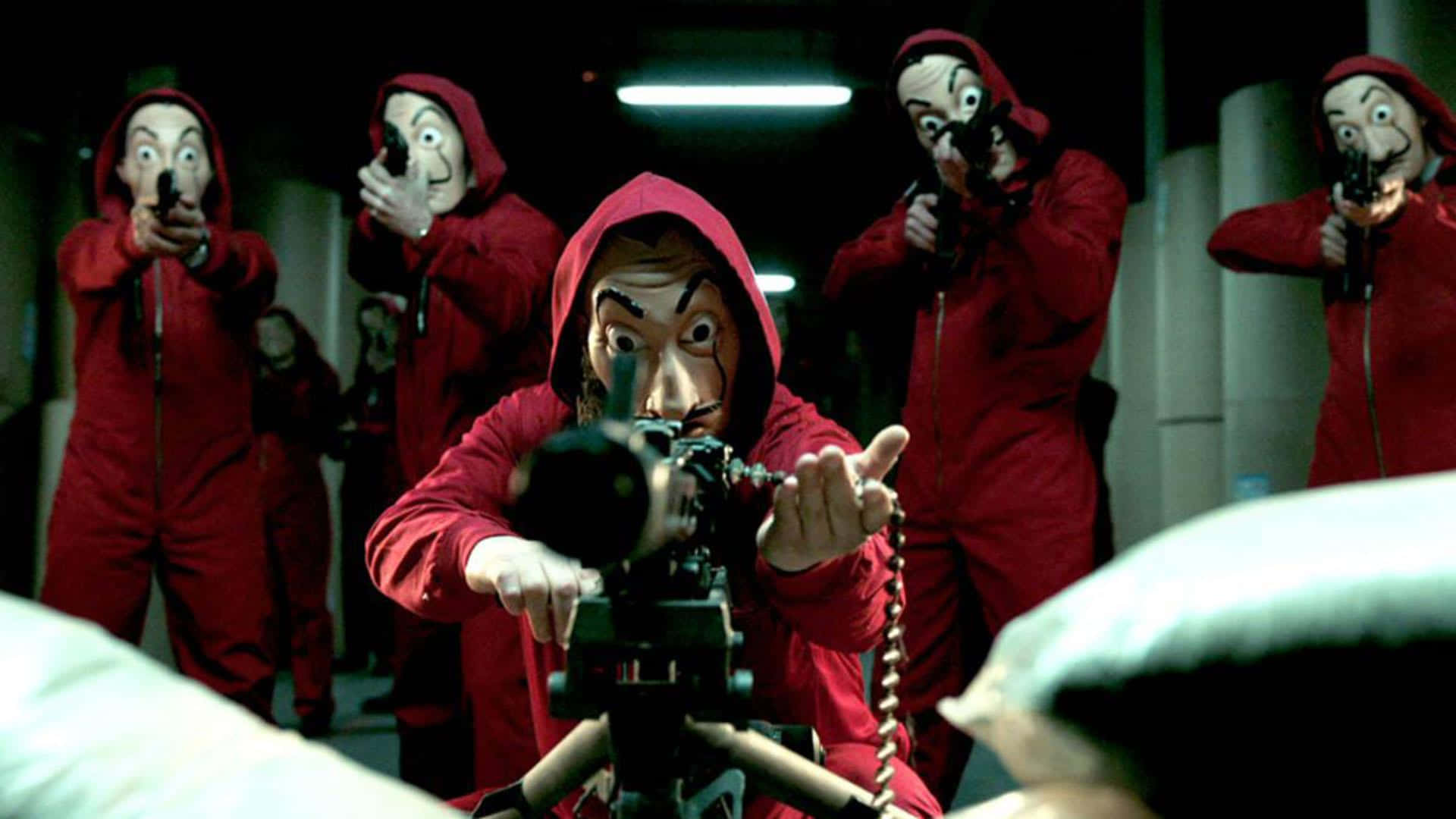 A Group Of People In Red Masks Holding A Gun