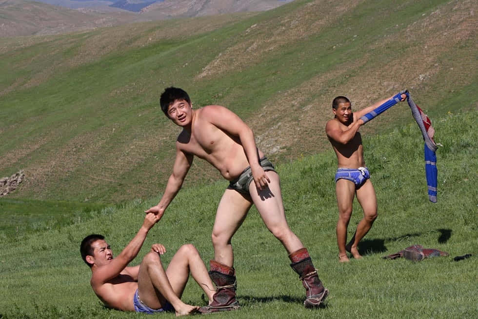 A Group Of Men In Underwear Playing In The Grass