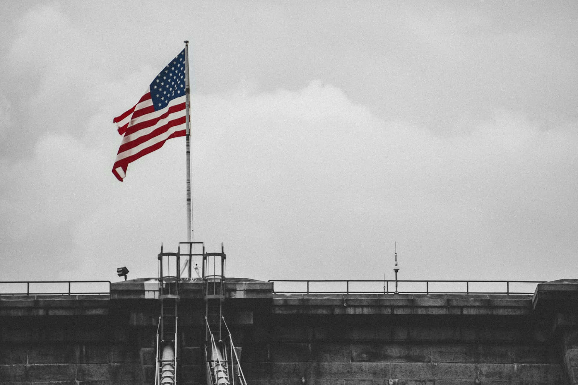 Monochrome American Flag Over Building Wallpaper