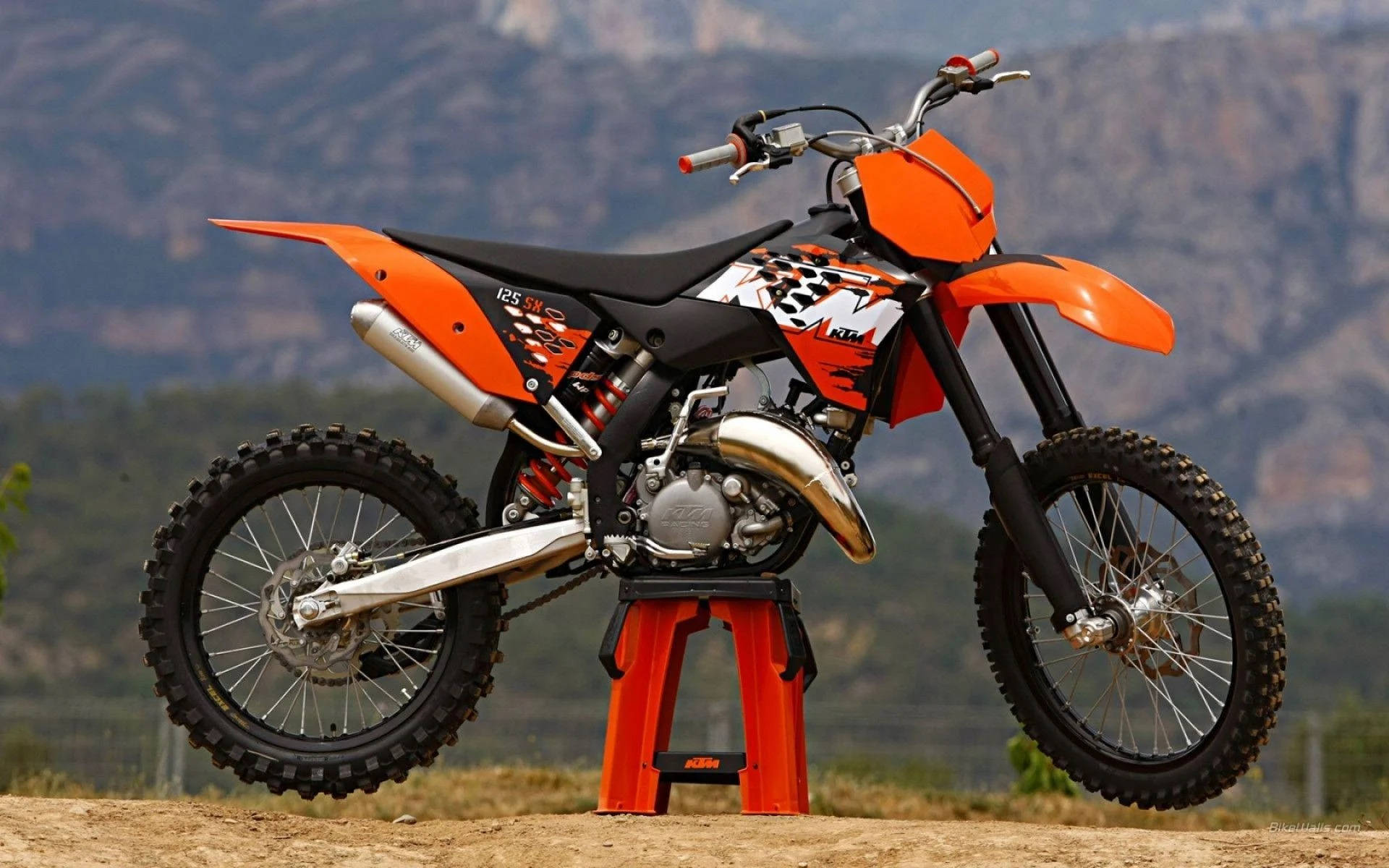 A Dirt Bike Is Sitting On A Stand In The Middle Of A Field Wallpaper
