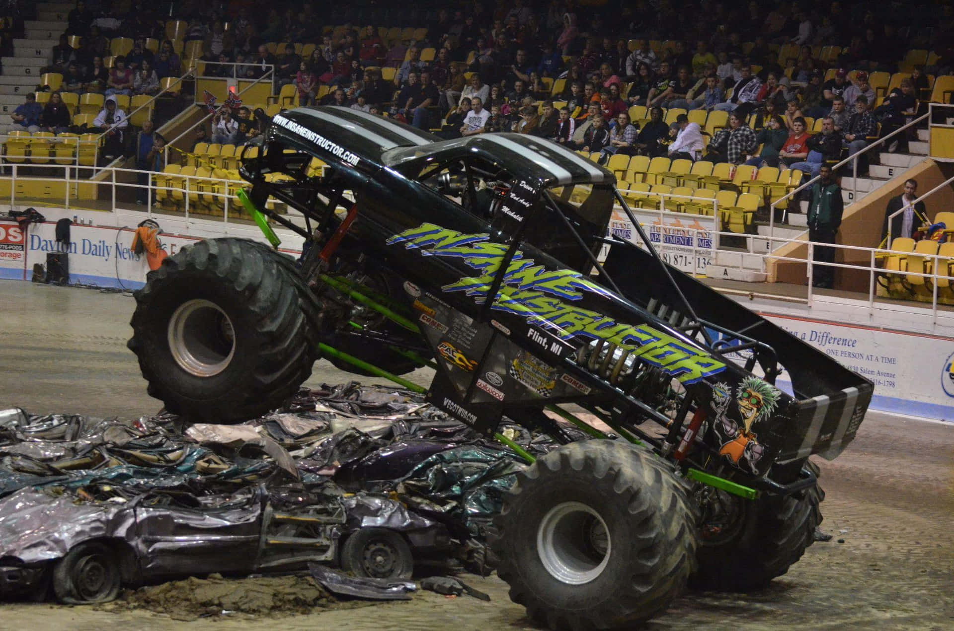 A Monster Truck Is Jumping Over A Pile Of Wrecks