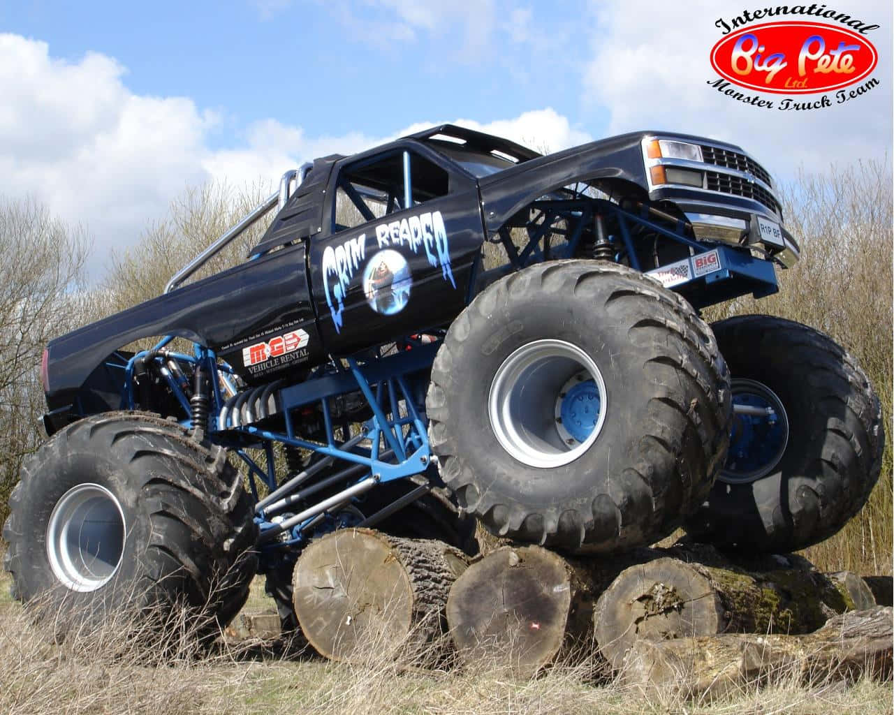 A Monster Truck Is On Top Of A Log