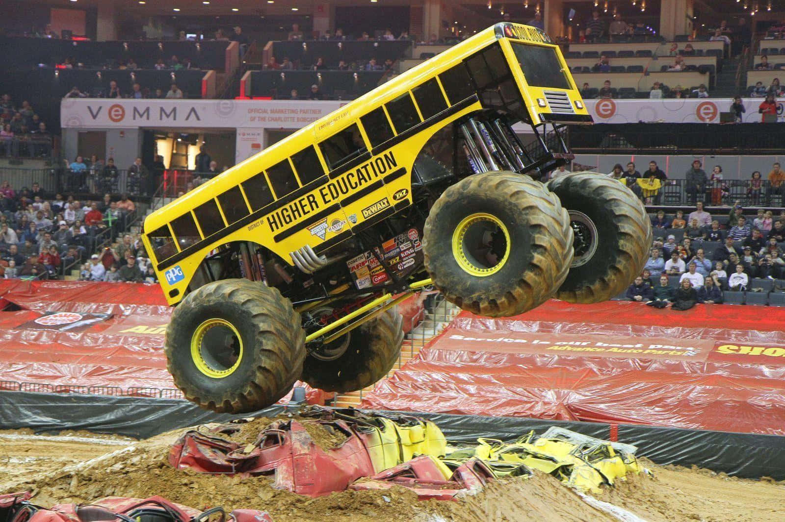 A Monster Truck Jumping Over A Dirt Field