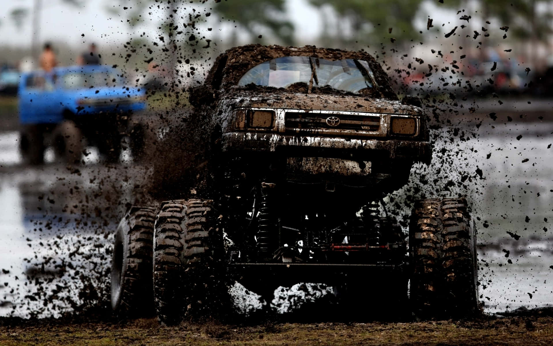 A Truck Driving Through Mud In A Muddy Field