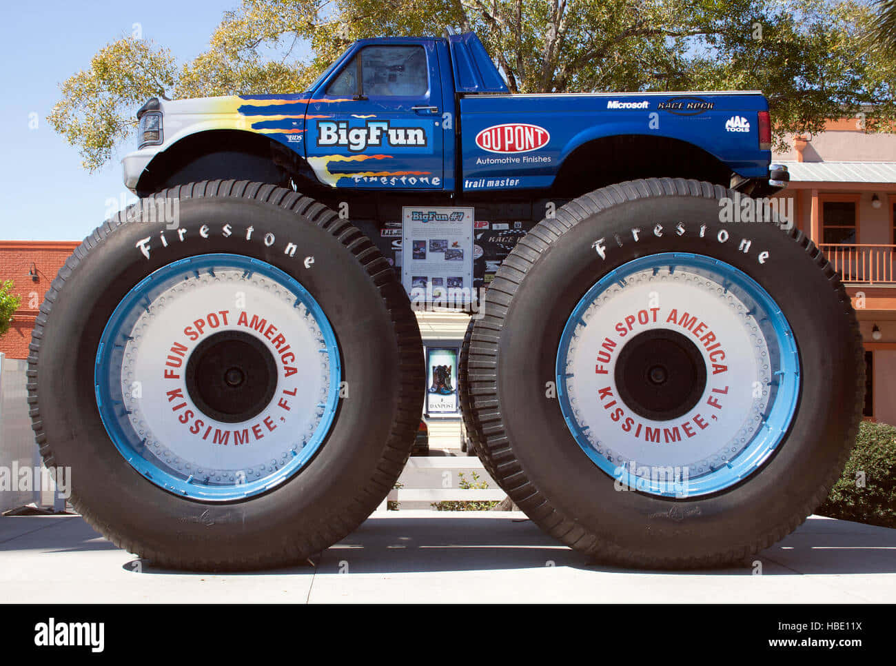 A Monster Truck With Large Tires On Display In A Park - Stock Image