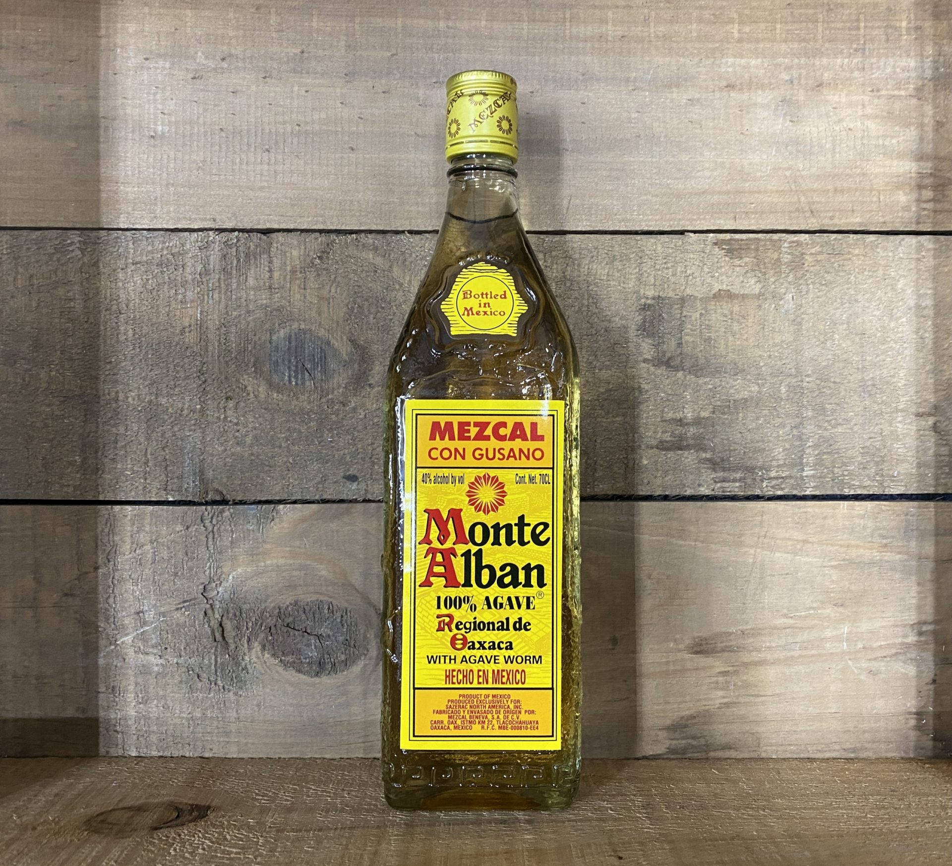 Montealban Mezcal Tequila Neben Einer Holzwand Wallpaper