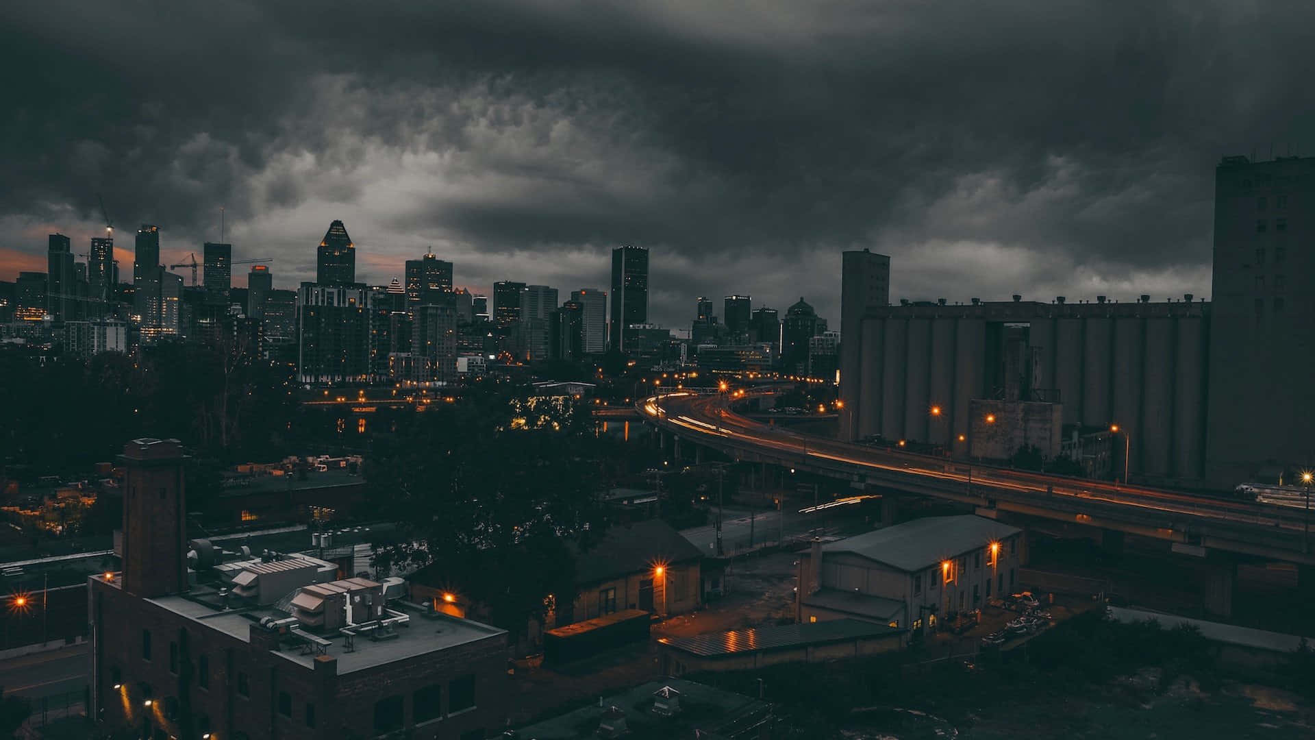 Moody_ Cityscape_ Under_ Stormy_ Skies Wallpaper