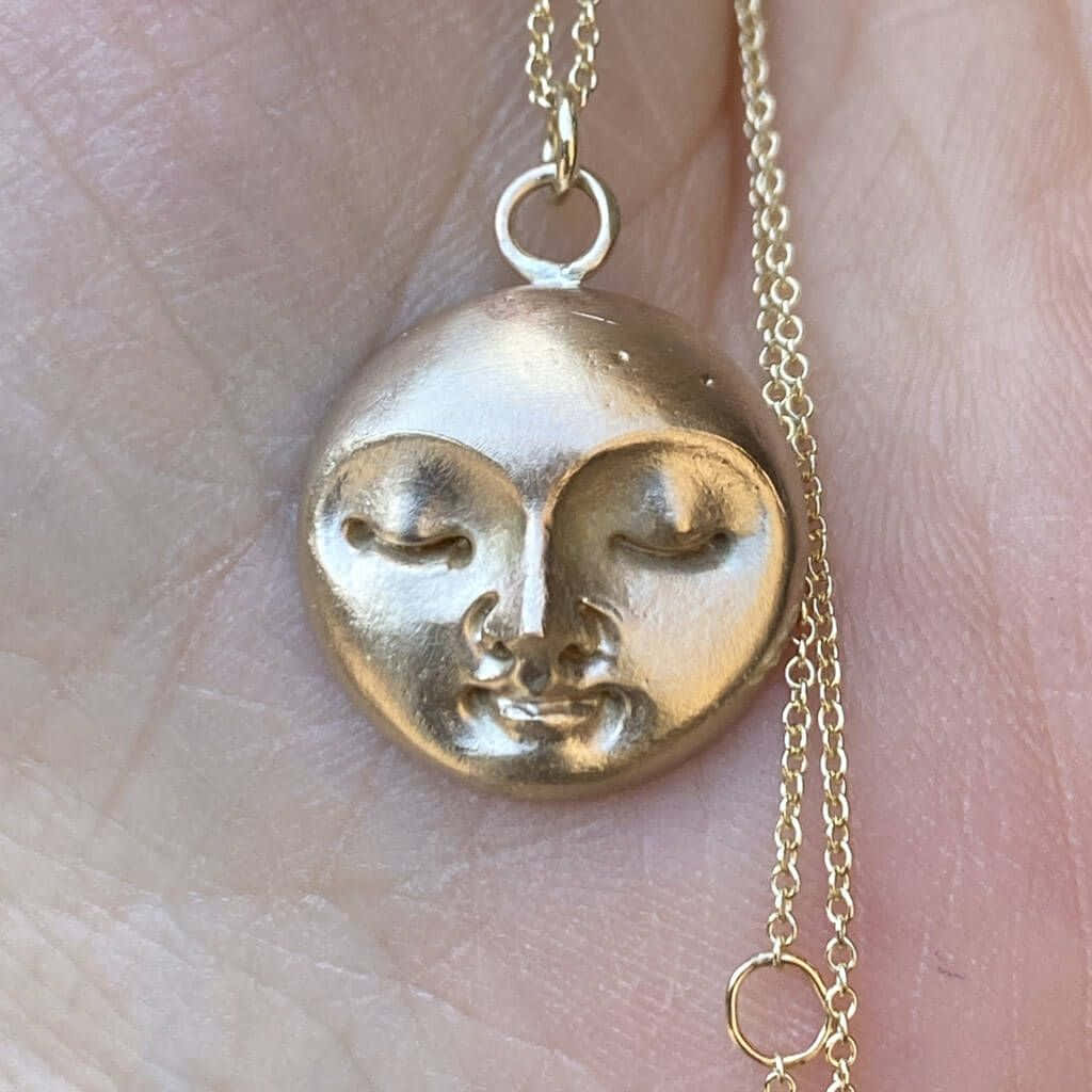 A Gold Moon Pendant On A Chain