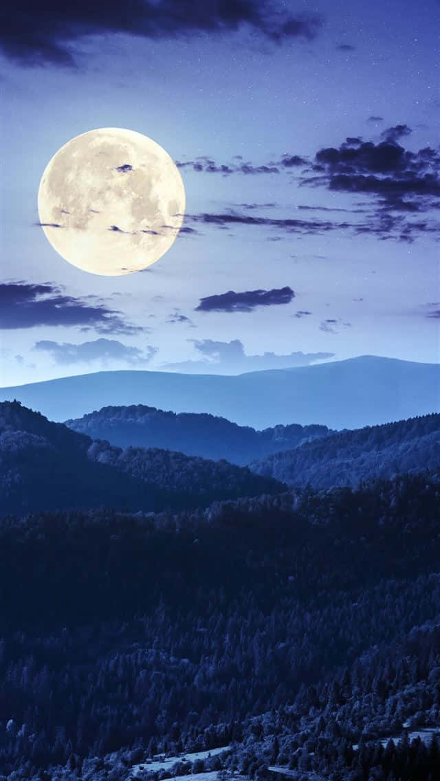 A Full Moon Rising Over A Mountain Wallpaper