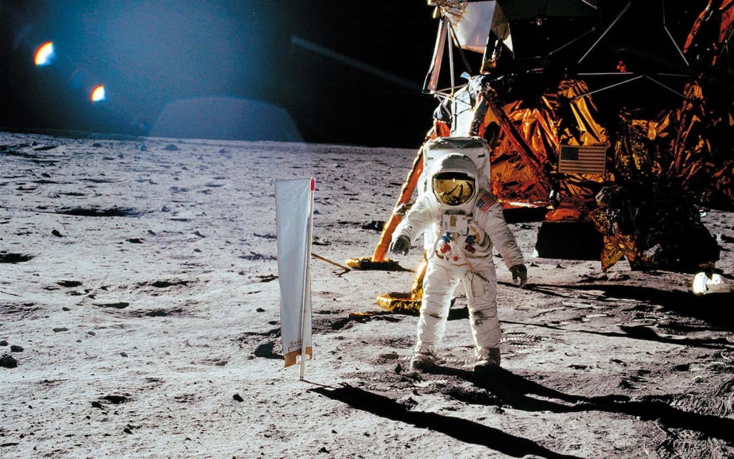 A Man In A Space Suit Standing On The Moon