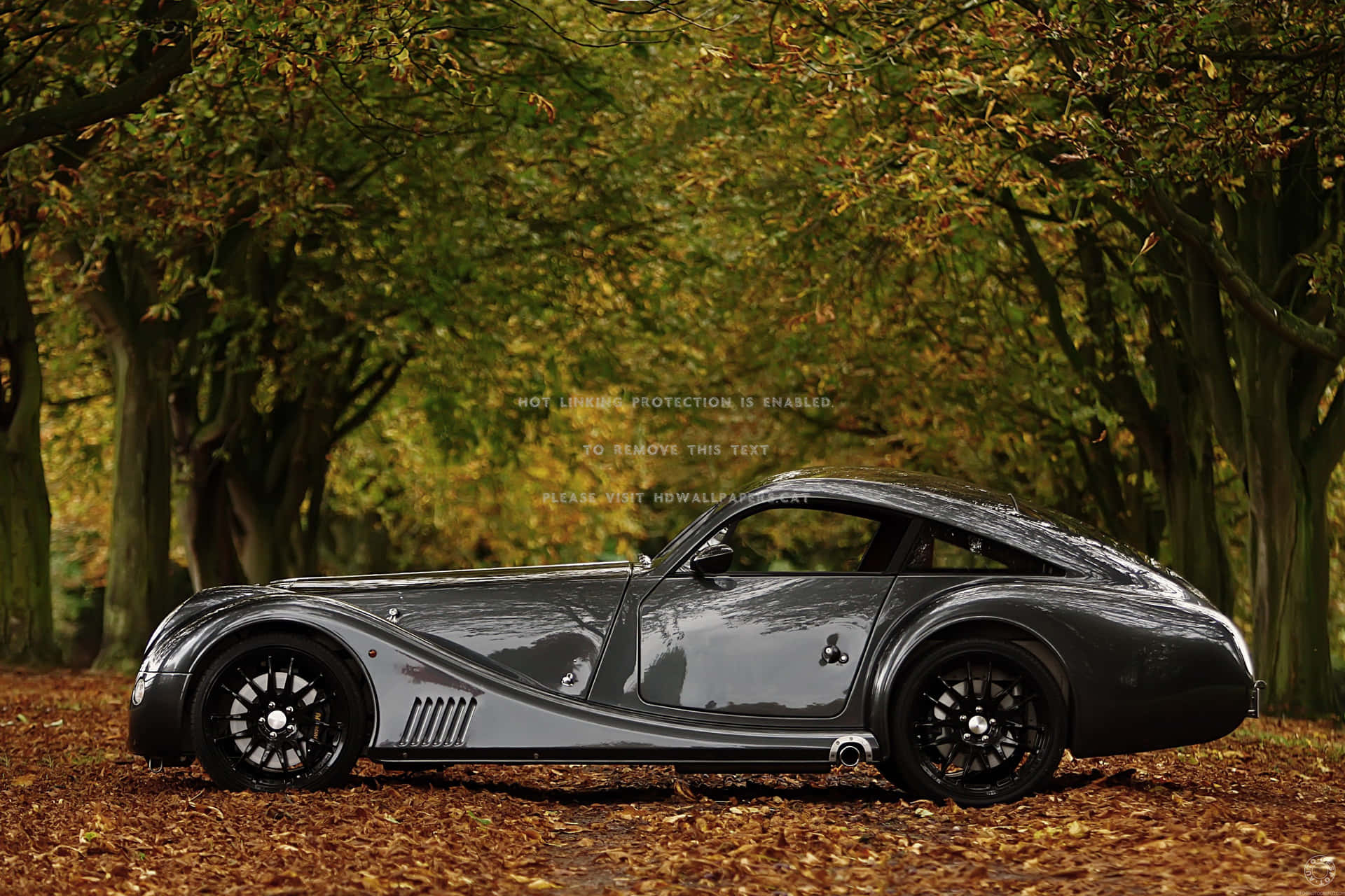 Modern Morgan sports car on a picturesque road Wallpaper