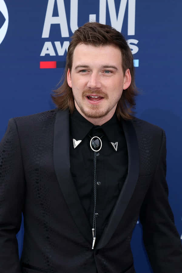 A Man In A Suit And Tie Standing On The Red Carpet