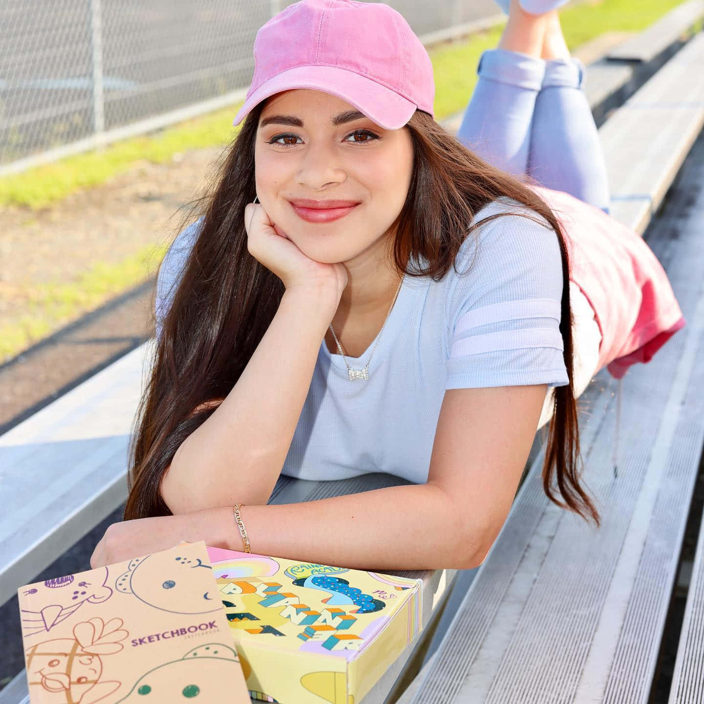 En pige ligger på en bænk med en pizzaboks. Wallpaper