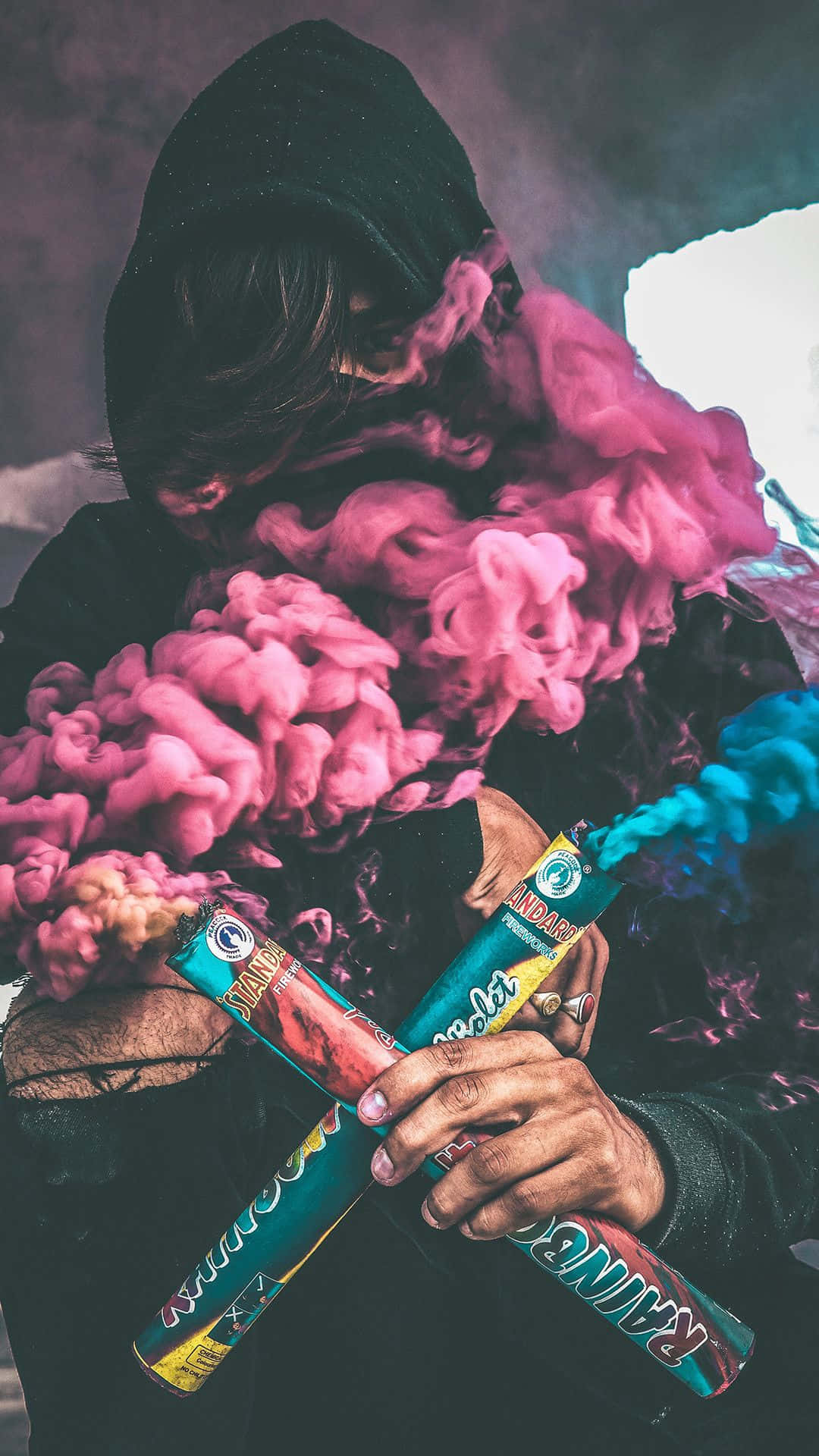 A Person Holding A Pink And Blue Smoke Wallpaper