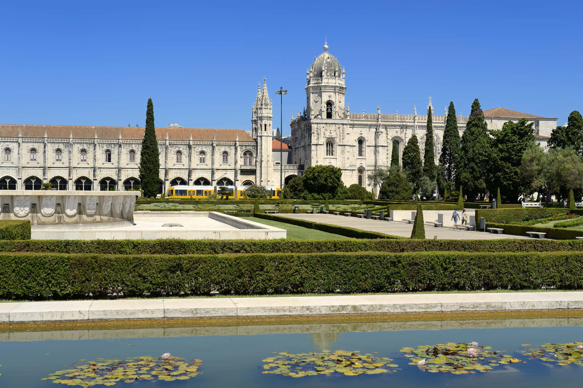 Beautiful reflection of Mosteiro Dos Jeronimos in a serene pond. Wallpaper