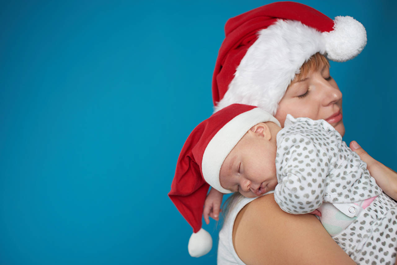 Mother And Baby Wearing Christmas Hats Wallpaper