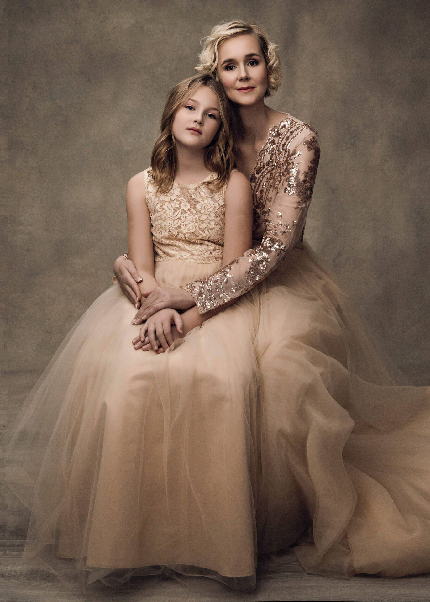 Loving Mother and Daughter in Matching Elegant Gowns Wallpaper