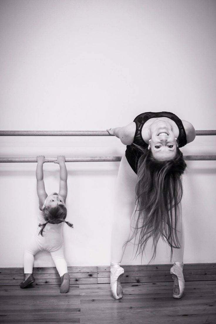 Mother helping her daughter workout at the ballet barre Wallpaper