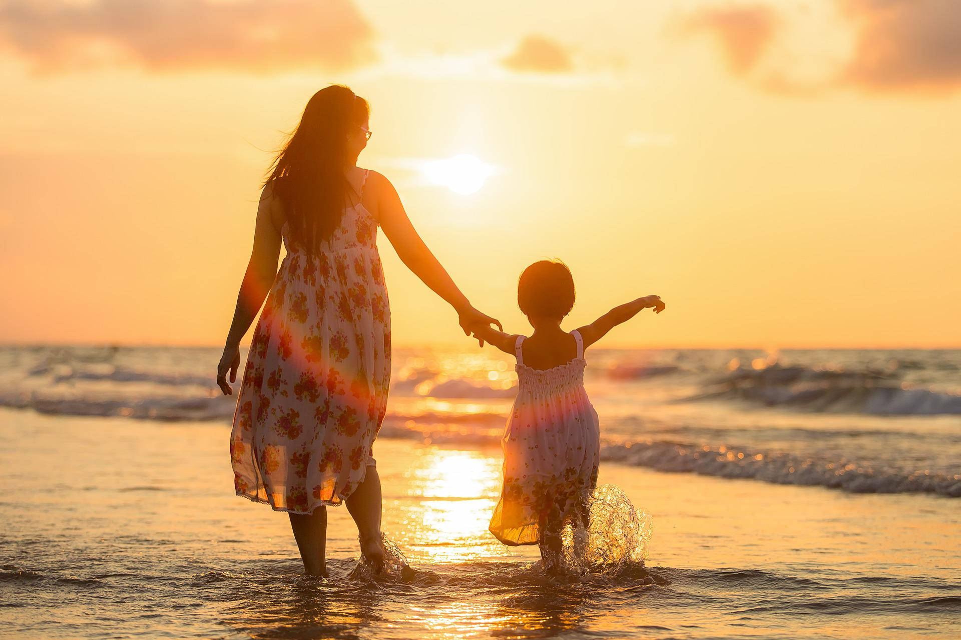 Moderen og datteren på solbeskinnede strande Wallpaper