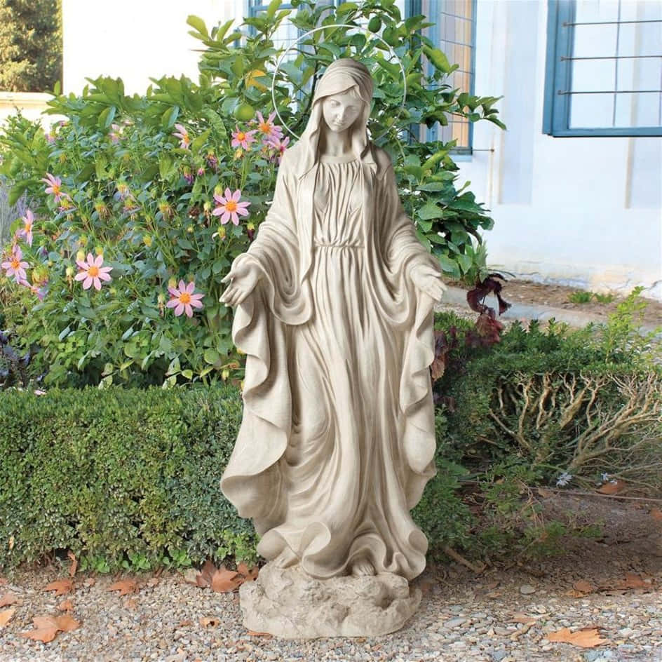 A Statue Of The Virgin Mary In Front Of A Garden