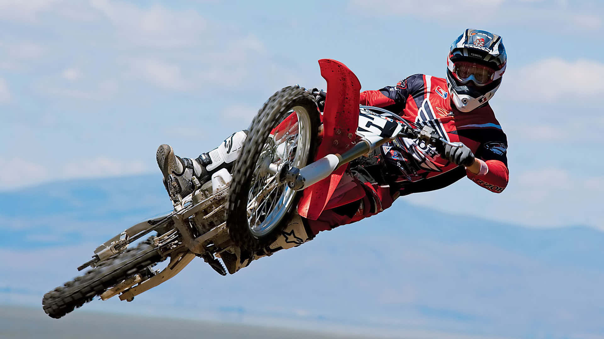 Motociclistadi Dirt Bike Che Si Gode Un'esperienza Fuoristrada Entusiasmante In Un Paesaggio Mozzafiato