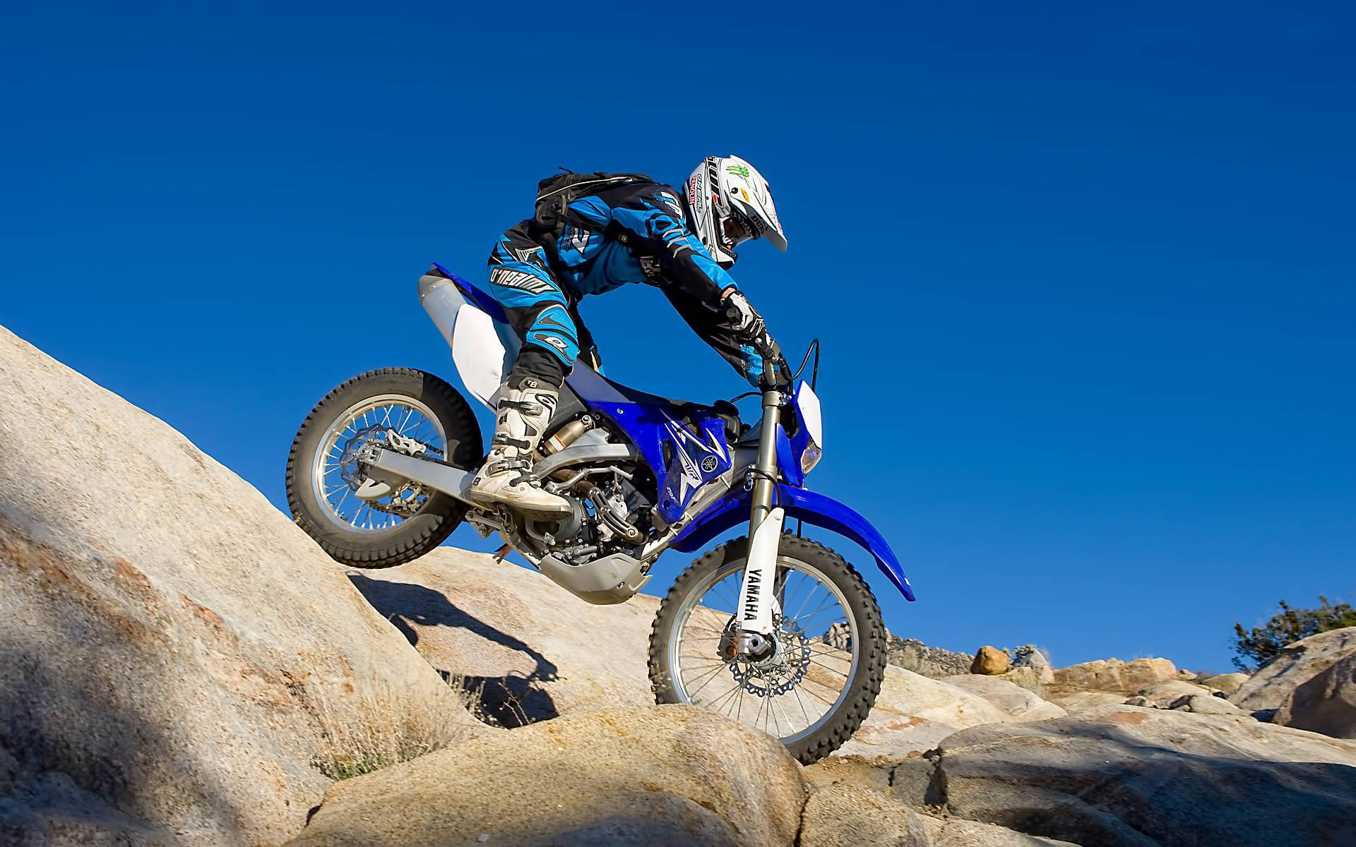 Extreme Motocross Rider in Rocky Scenery Wallpaper
