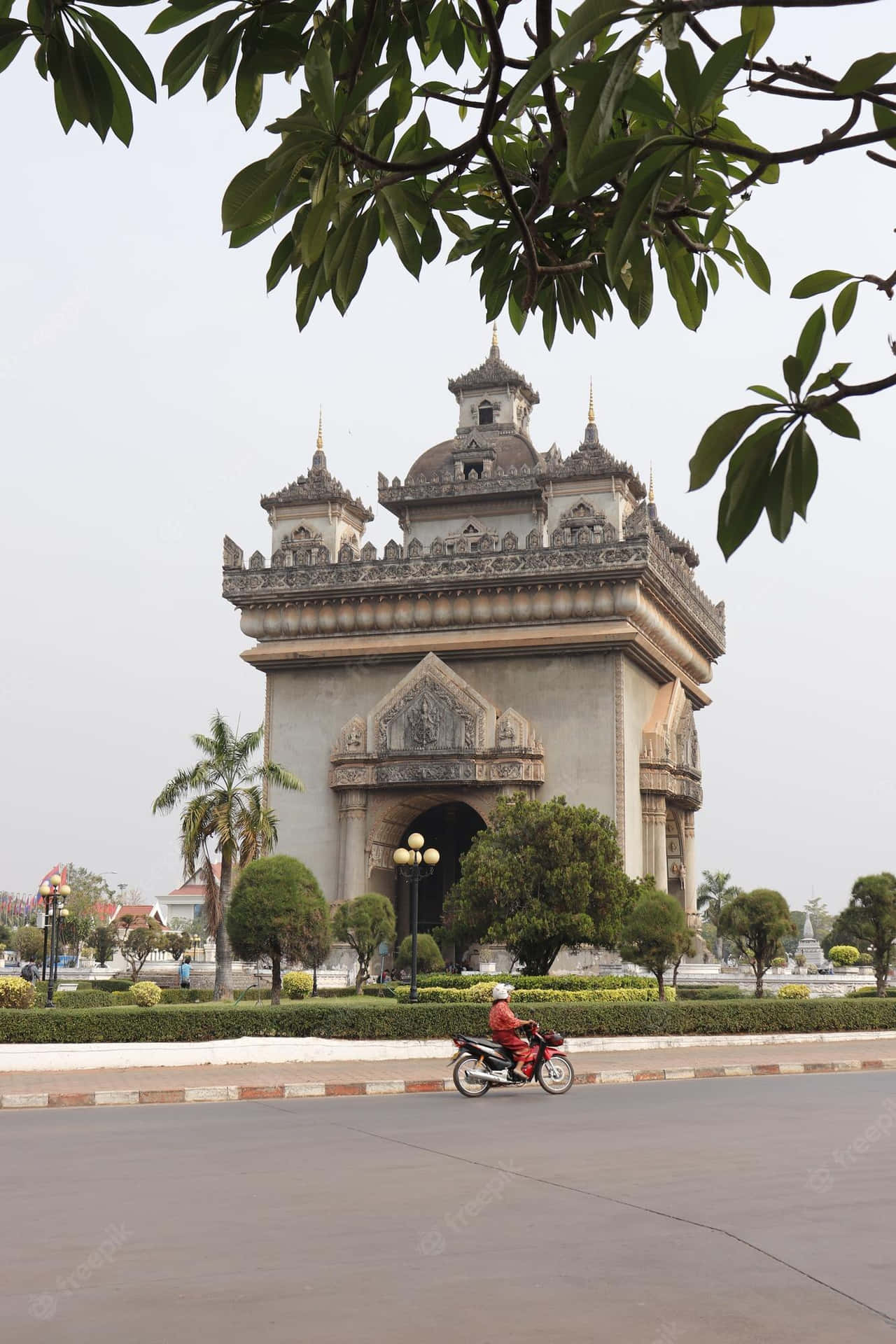 Motorcycle Passing By Patuxai Monument Wallpaper