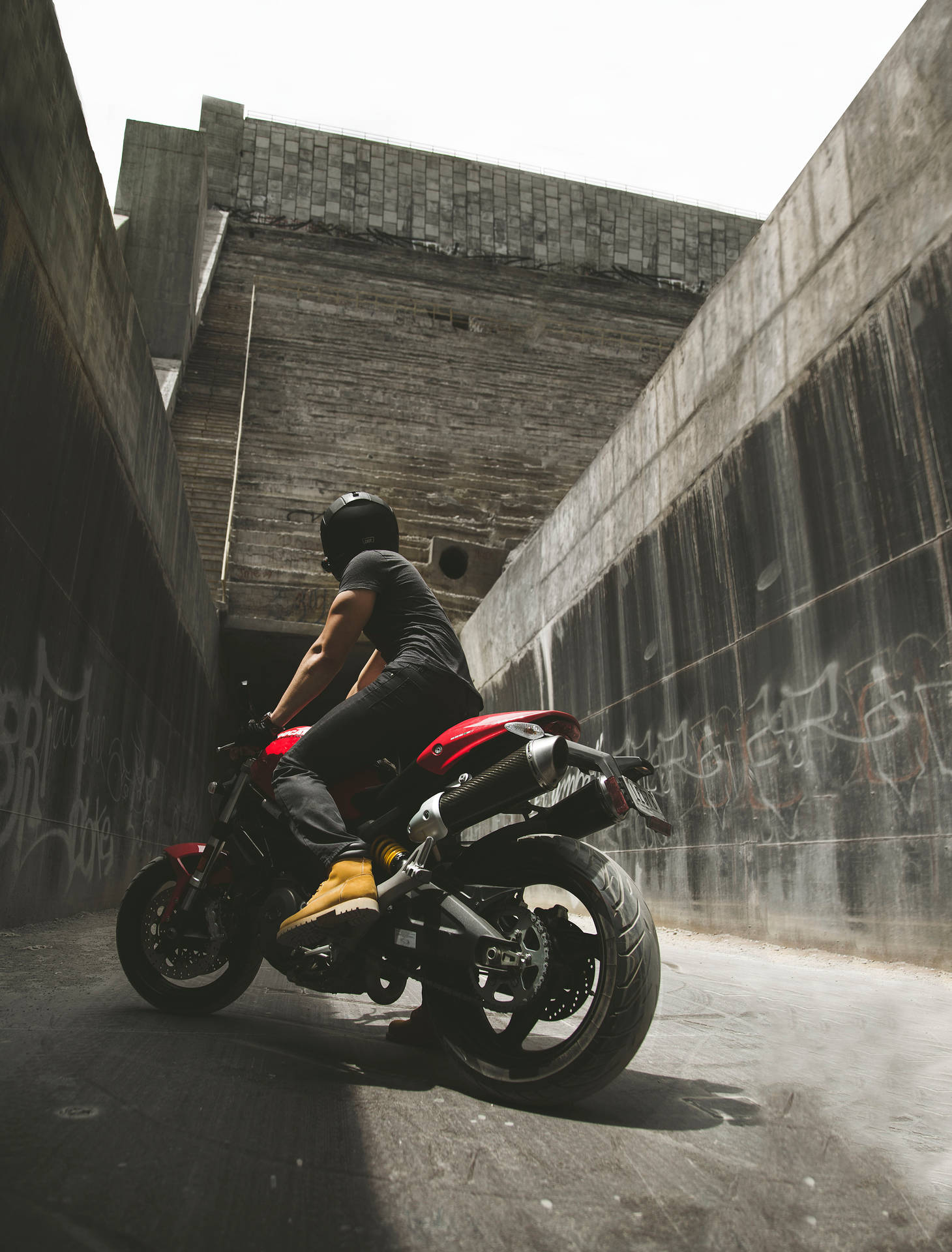 Motorcyclist Posing Between Concrete Walls