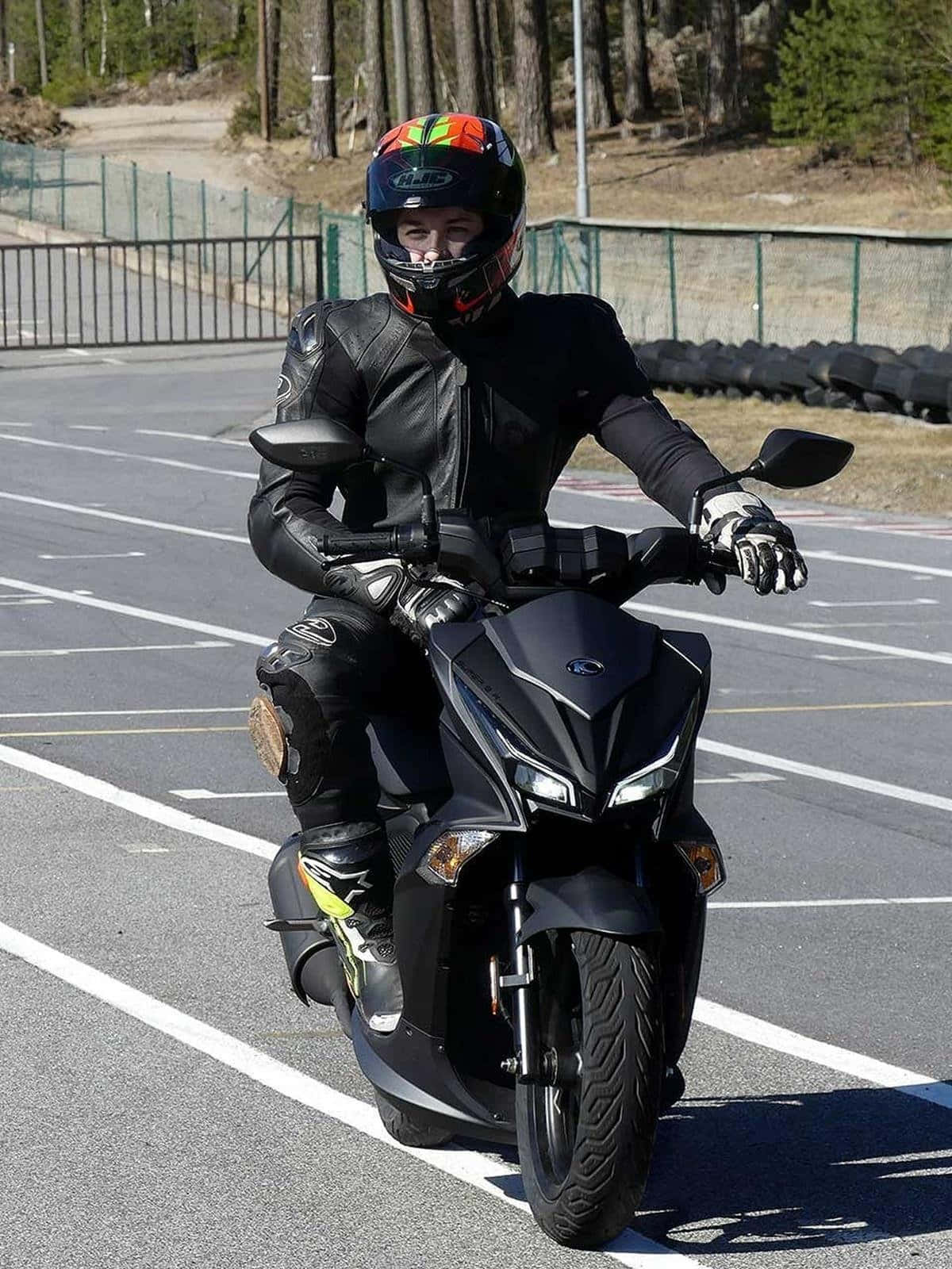 Motard Sur Scooter Kymco Dans Un Parking Fond d'écran