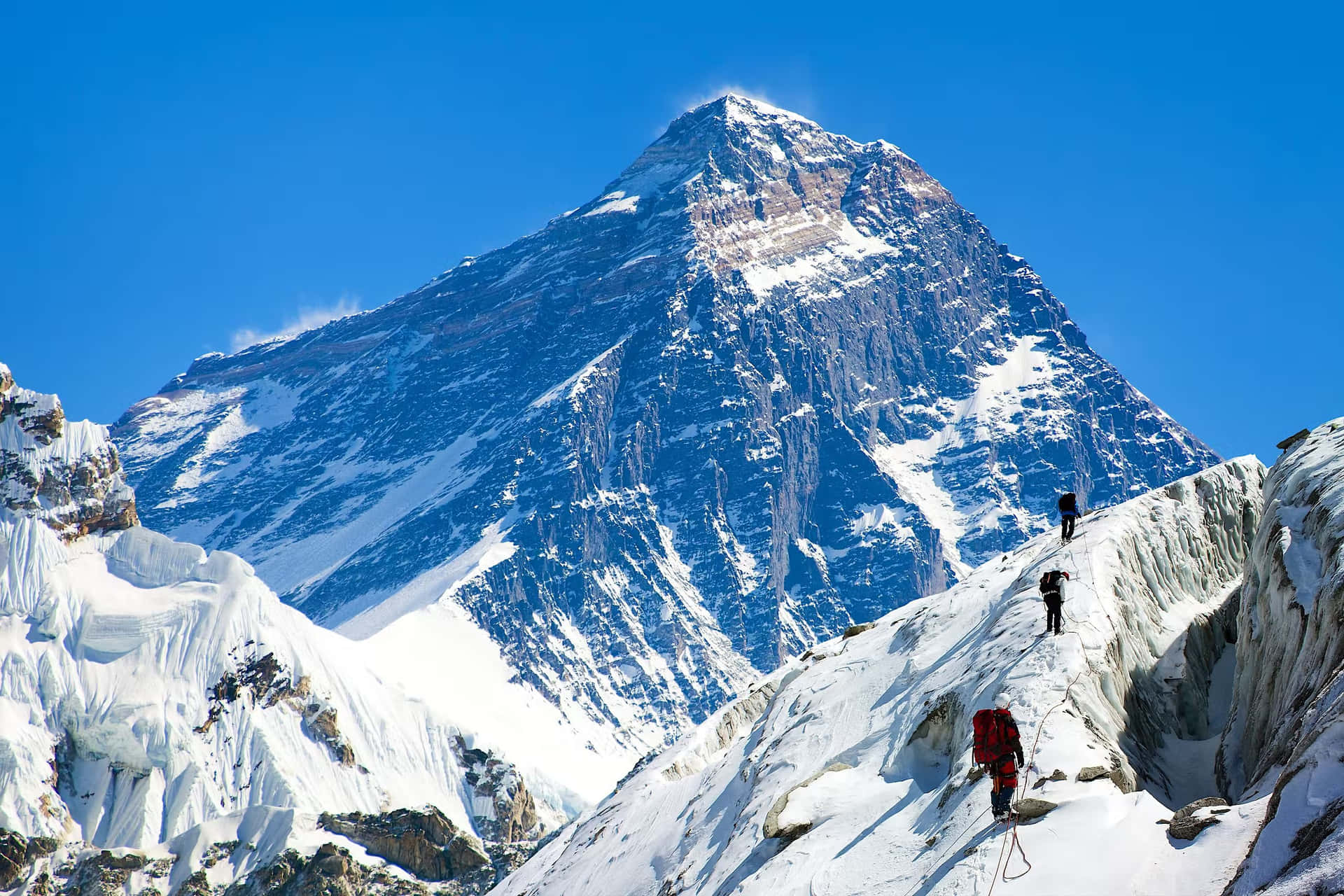 A Group Of People Climbing Up A Snowy Mountain