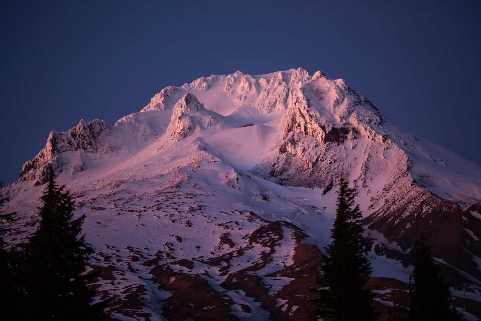 A Mountain Peak Is Lit Up At Dusk
