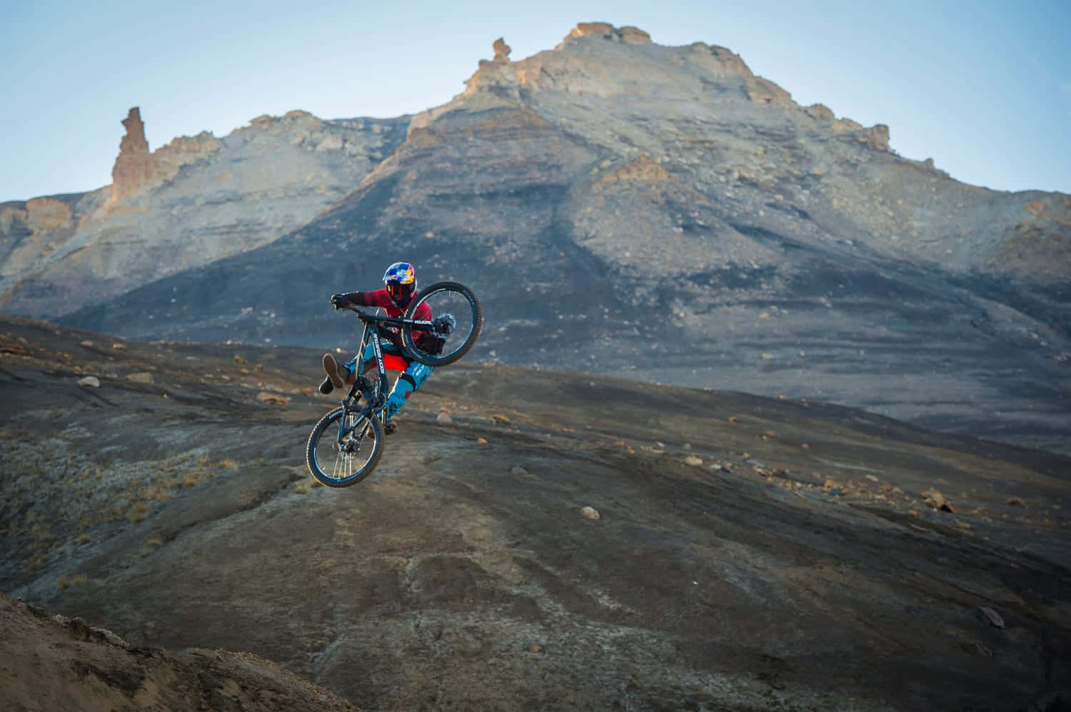 Mountain Bike Stunt Against Rugged Terrain.jpg Wallpaper
