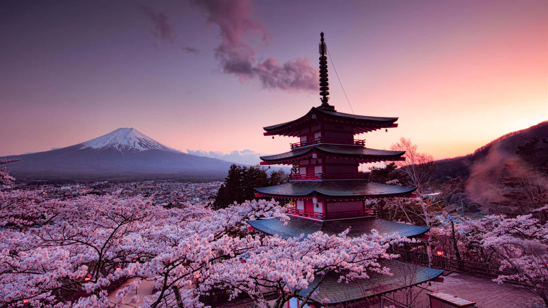 A Pagoda With Cherry Blossoms And A Mountain In The Background Wallpaper
