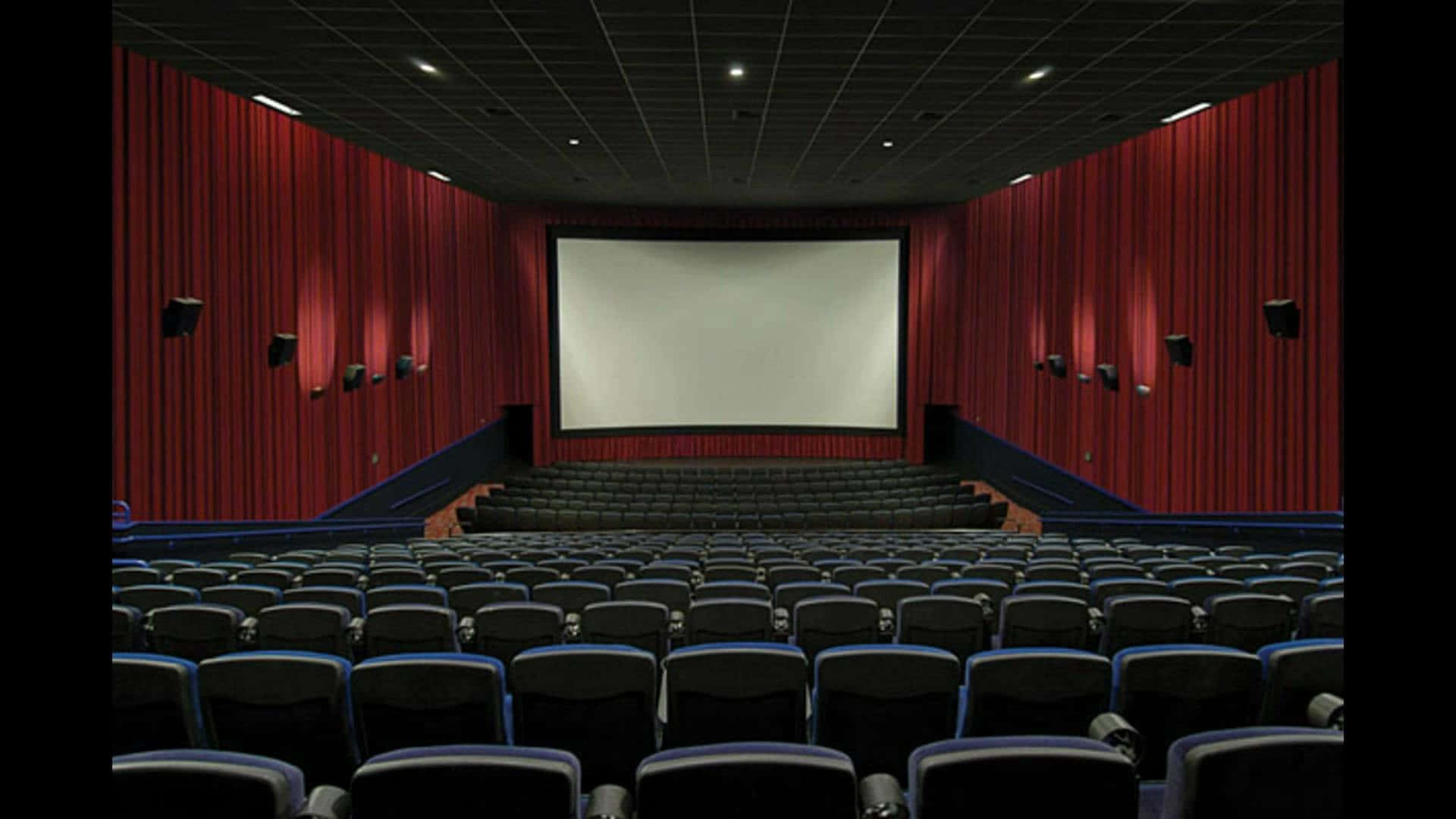 A Cinema With Rows Of Seats And A Screen Wallpaper