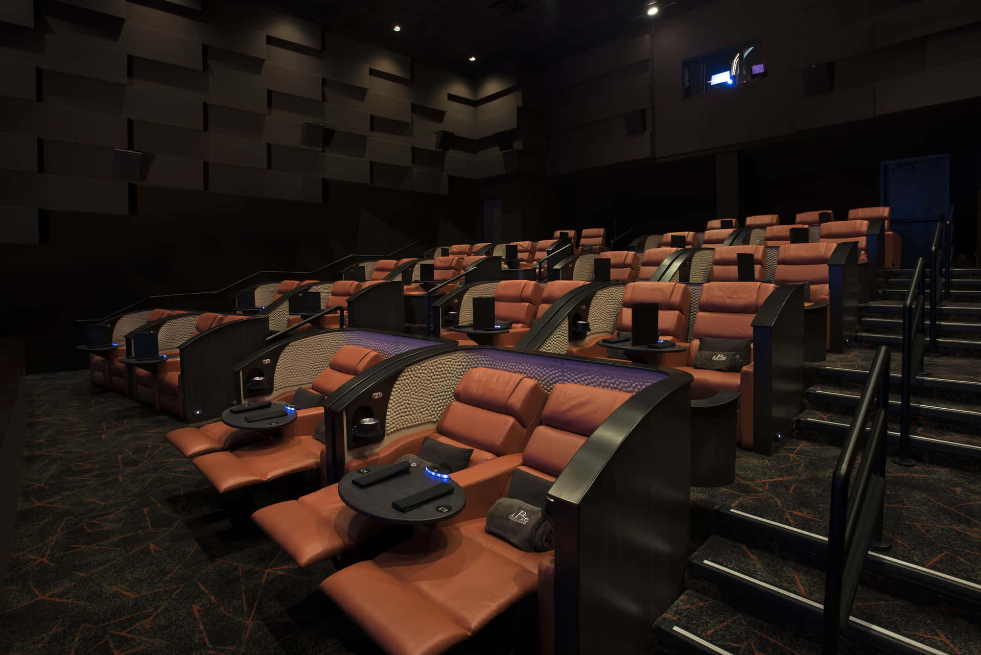 A Movie Theater With Seats And A Screen Wallpaper
