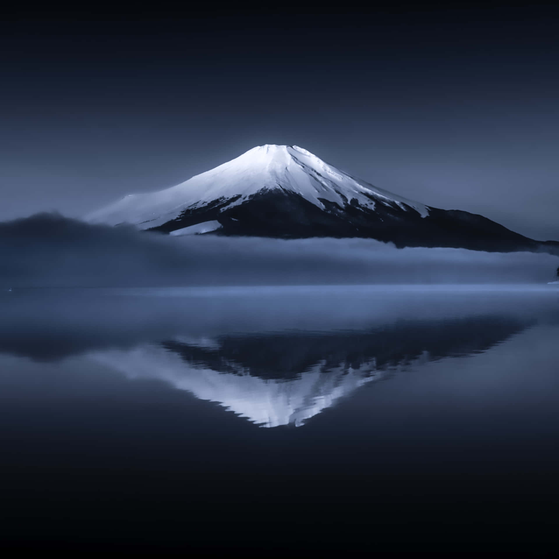 A Mountain Is Reflected In A Lake At Night