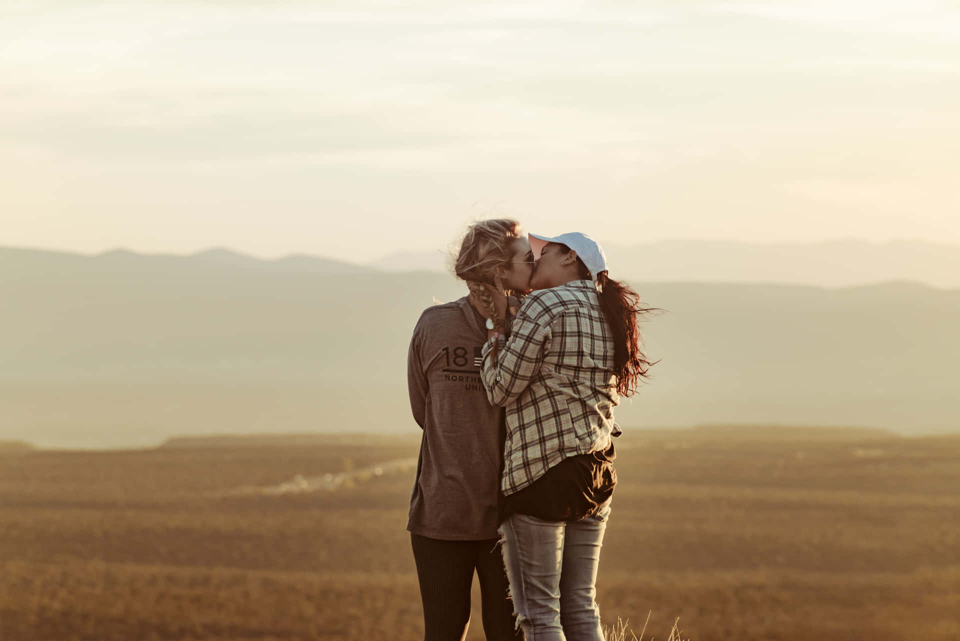 Mujeres Lesbianas Kissing In Open Area Wallpaper