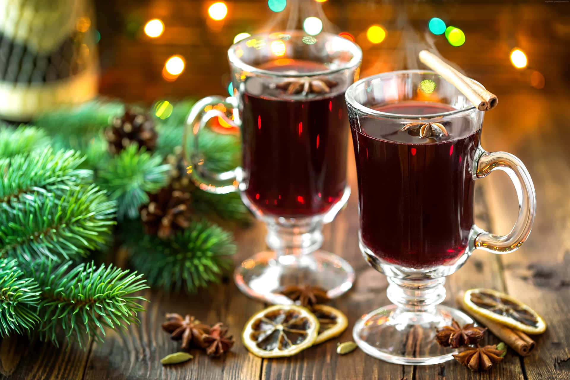 A steaming cup of aromatic mulled wine garnished with fresh fruits and spices against a cozy, festive backdrop. Wallpaper
