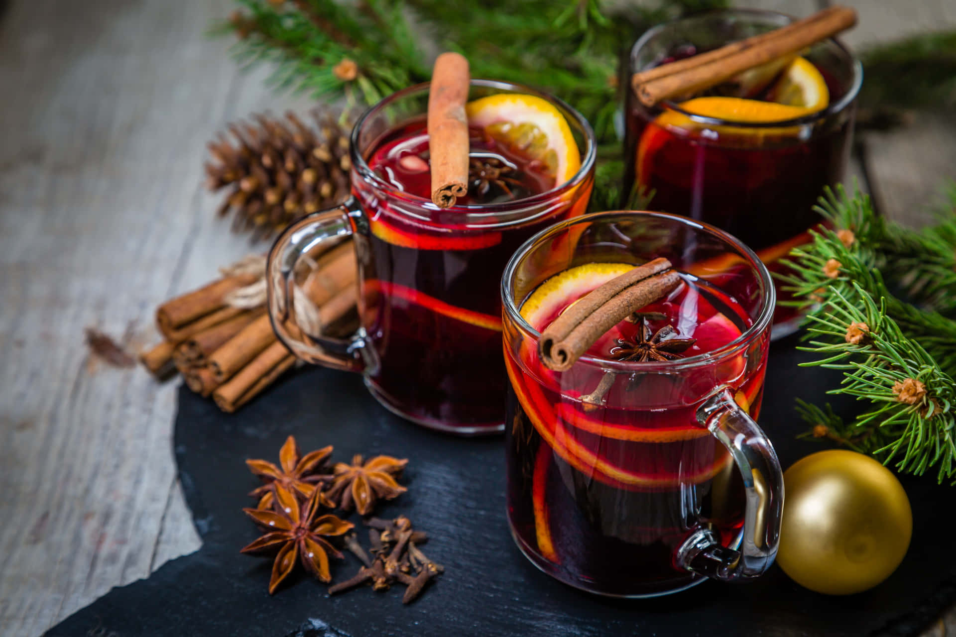Delicious Mulled Wine with Winter Spices and Citrus Fruits in a Cozy Atmosphere Wallpaper