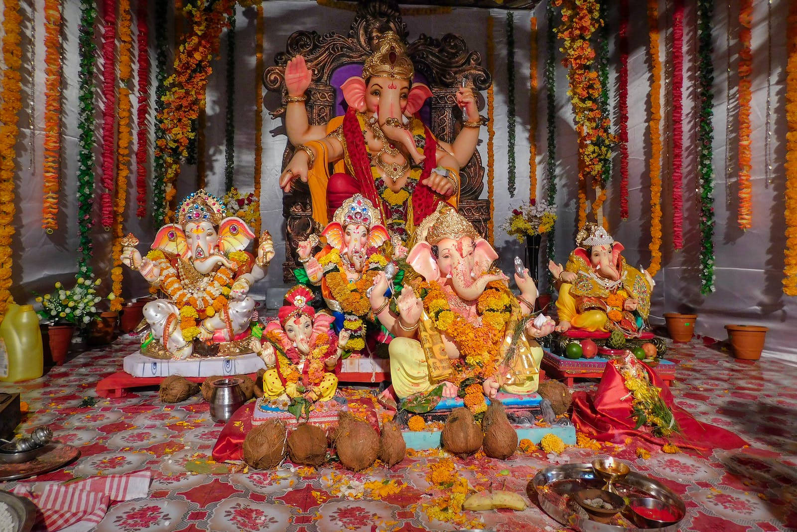 Multiple Vinayaka Statues With Offerings Wallpaper